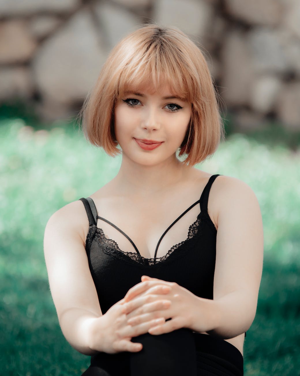 portrait of a woman in black bralette posing with hands on her knees